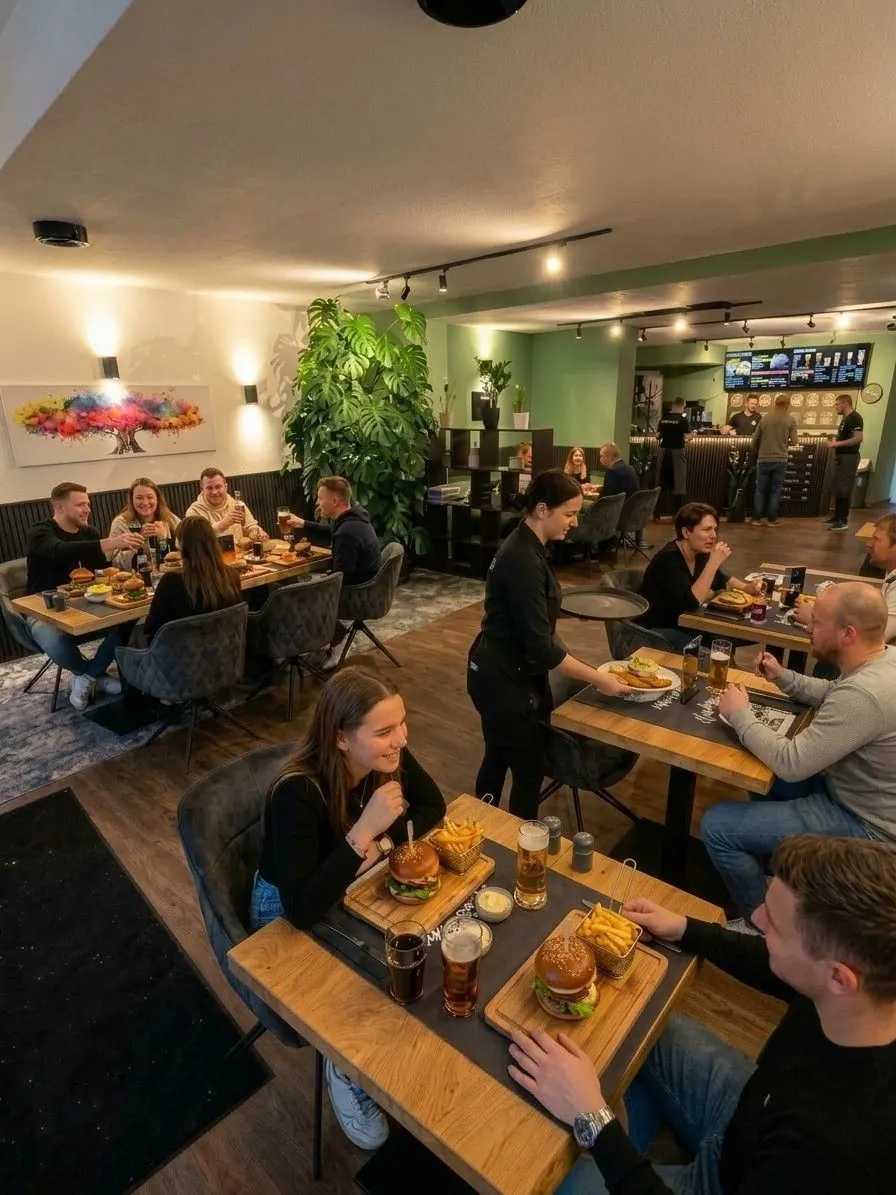 Gäste mit Burgern im Gastraum von Onkel Emma